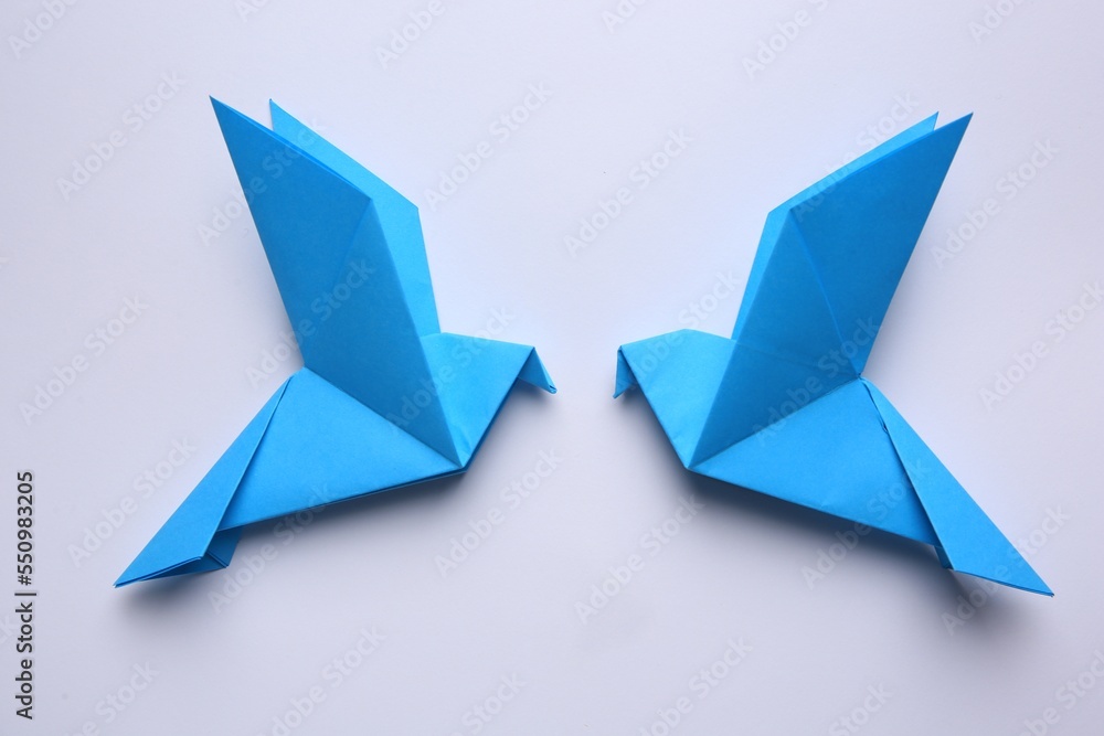 Beautiful blue origami birds on white background, flat lay. Beautiful blue origami birds on white background, flat lay.