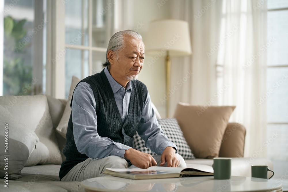 sad asian old man sitting alone on couch at home sad asian old man sitting alone on couch at home