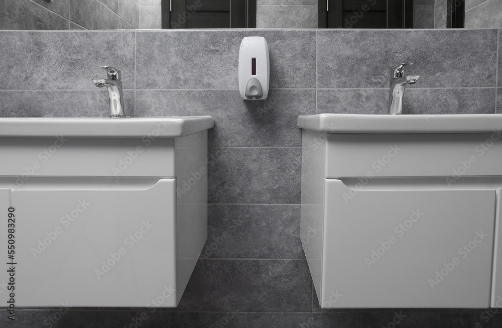 Fototapeta premium Public toilet interior with stylish white sinks and grey tiles