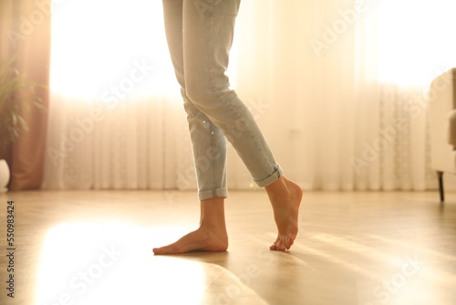 Barefoot woman at home, closeup. Floor heating system