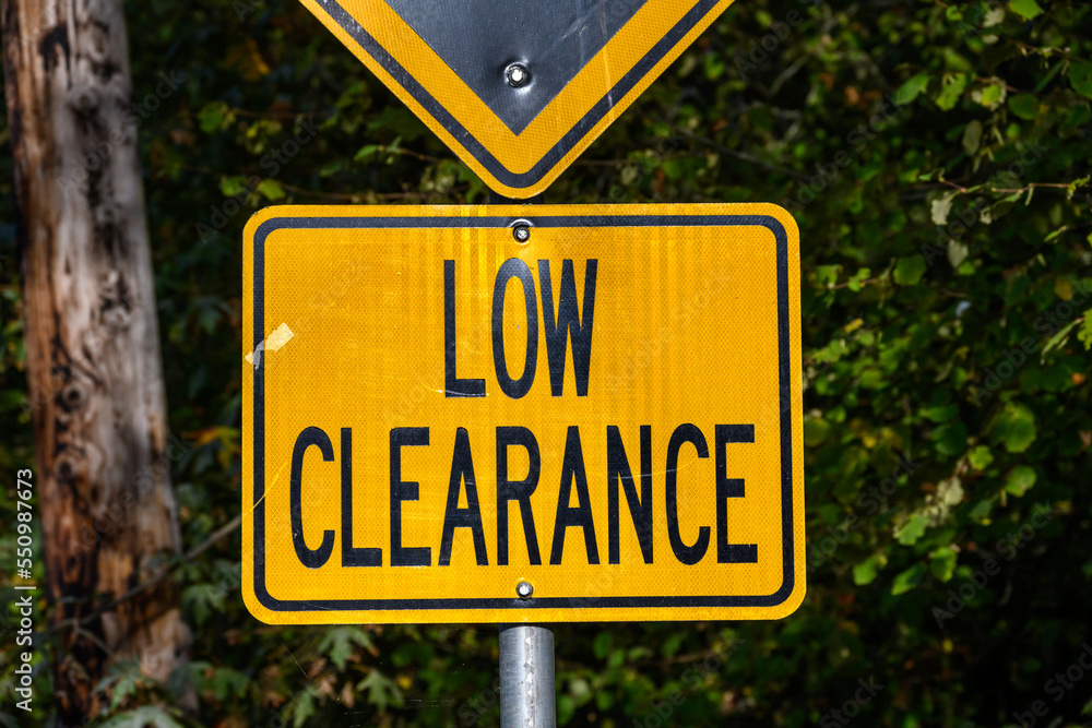 Yellow road sign, Low Clearance, caution to tall vehicles
Yellow road sign, Low Clearance, caution to tall vehicles