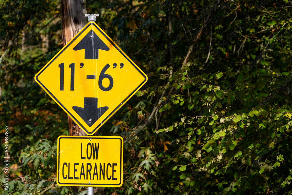 Yellow road sign, Low Clearance of 11’ 6”, caution to tall vehicles
