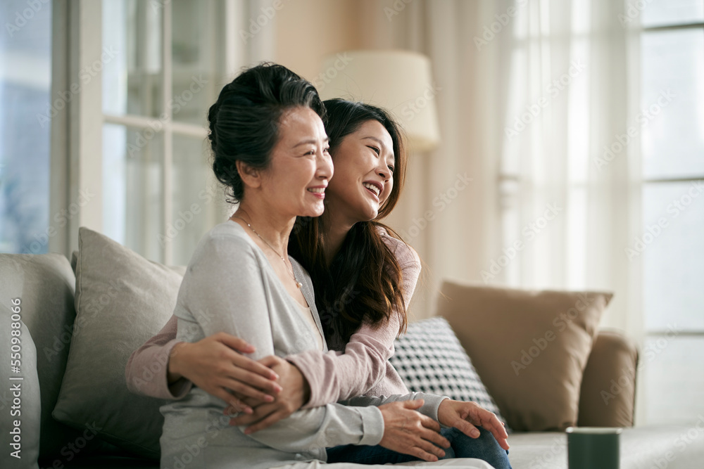 asian adult daughter and senior mother hugging each other at home asian adult daughter and senior mother hugging each other at home