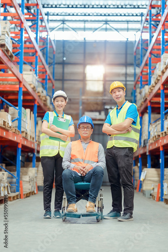 The supervisor is handicapped with a wheelchair inspecting the work background in warehouse.logistic business export ,Warehouse worker checking packages on store