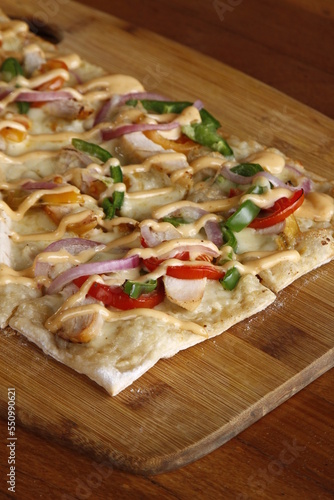 Square pizza with healthy ingredients on a wood board