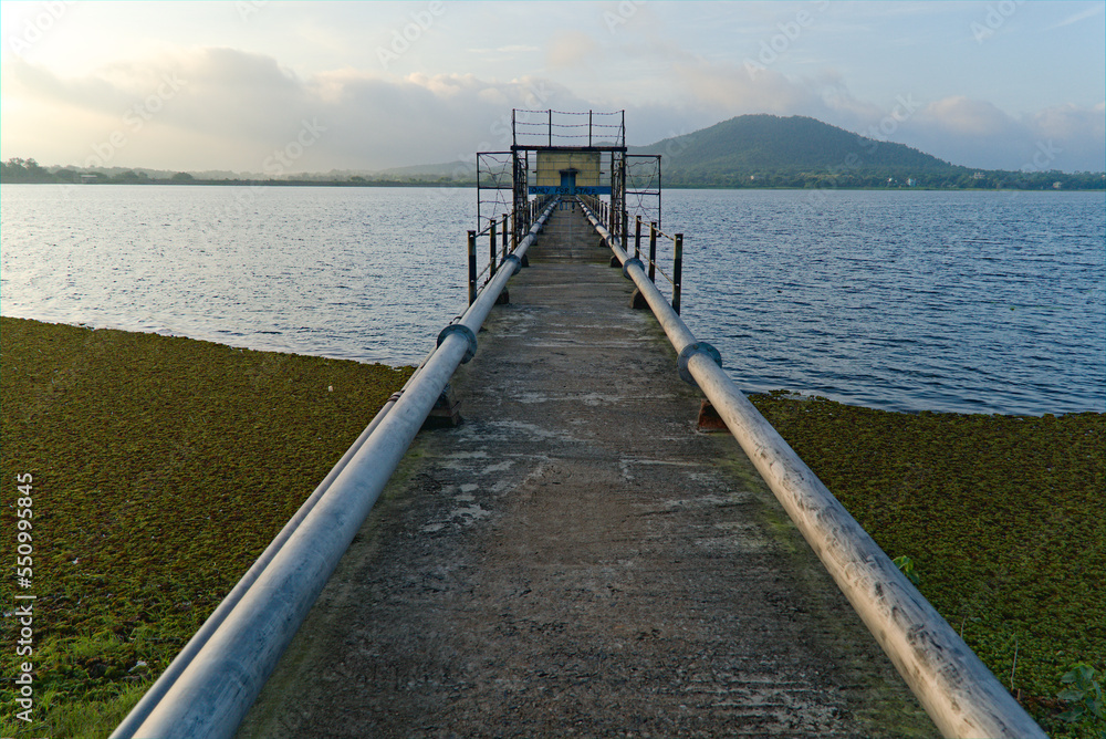 Fototapeta premium 14.07.2021. purulia, west bengal, india. pump house leading to th middle of lake with pipeline in purulia, india