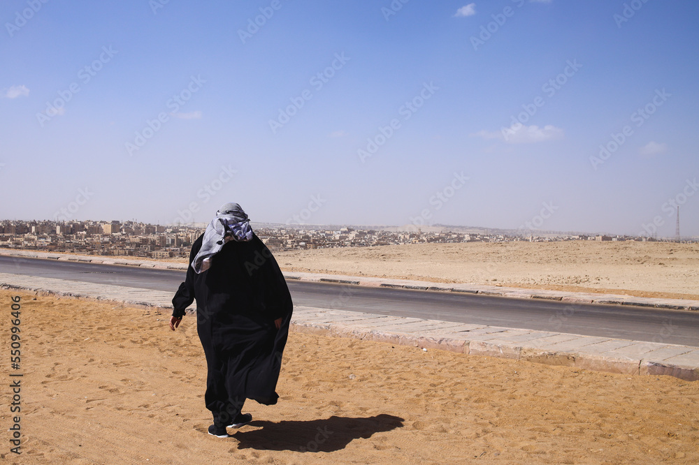 Woman muslim tourist walks on the desert Woman muslim tourist walks on the desert