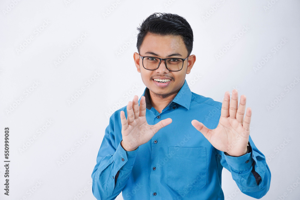 Displeased handsome young asian businessman with glasses in wearing blue shirt showing stop sign isolated on white background Displeased handsome young asian businessman with glasses in wearing blue shirt showing stop sign isolated on white background