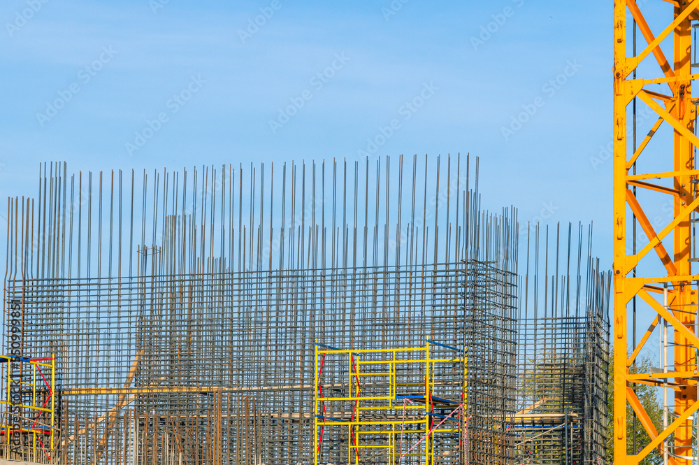 The foundation on reinforced concrete piles and the frame during the construction of a multi-storey building. Reinforcement of reinforced concrete columns. Construction of high-rise buildings. The foundation on reinforced concrete piles and the frame during the construction of a multi-storey building. Reinforcement of reinforced concrete columns. Construction of high-rise buildings.