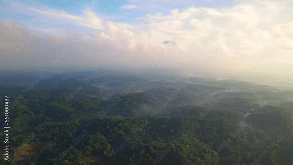 The tranquil landscape offers a panoramic view of distant mountains veiled by a blanket of clouds The tranquil landscape offers a panoramic view of distant mountains veiled by a blanket of clouds