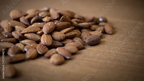 Organic almond nuts on wood table selective focus   top view. Healthy snack Delicious roasted sweet almonds  nuts close-up.