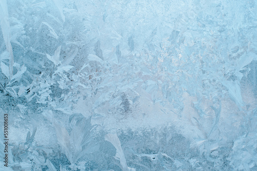 Textured surface of frozen window glass on winter day. Drawings of frost and ice on glass