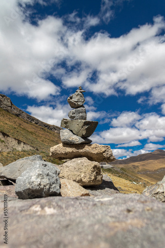Apacheta Andean tradition, stone on stone with background of the Peruvian highlands