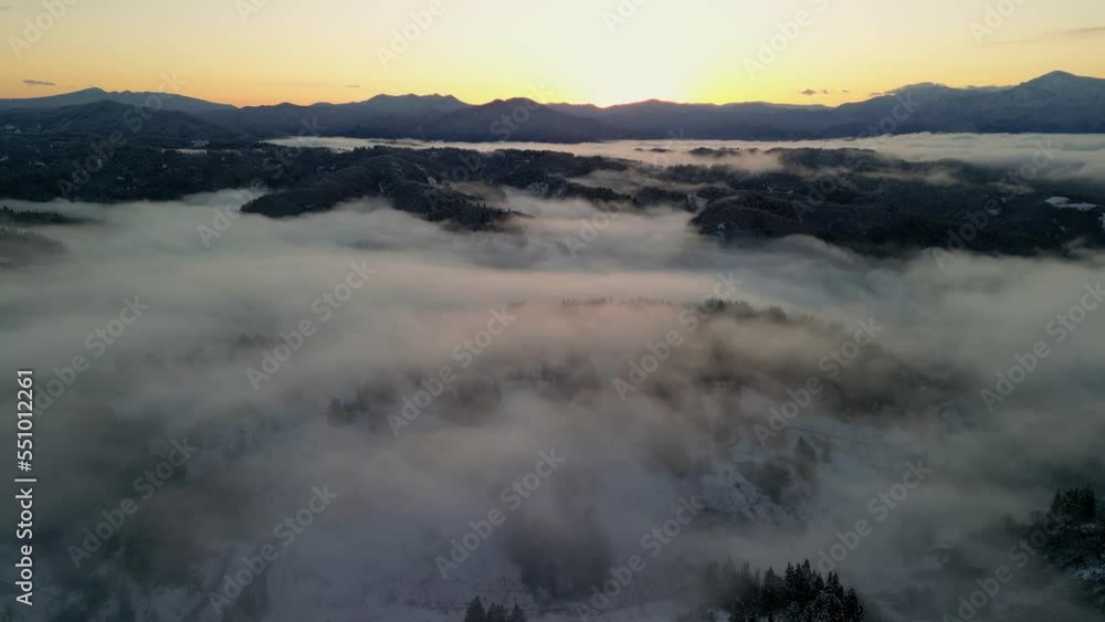 雲海に覆われた初雪の積もった夜明け前の里山を空撮しました 雲海に覆われた初雪の積もった夜明け前の里山を空撮しました