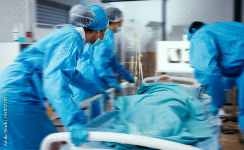 Women, man and hospital bed in motion blur of emergency surgery, healthcare wellness or risk condition operation. Doctors, nurses and medical workers with patient in busy er, theatre room or teamwork photo