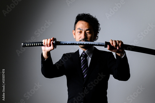 A businessman in a suit holding a sword.