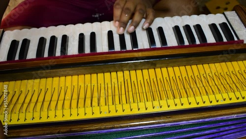 Close up shot of a musician playing Indian traditional musical instrument harmonium. photo