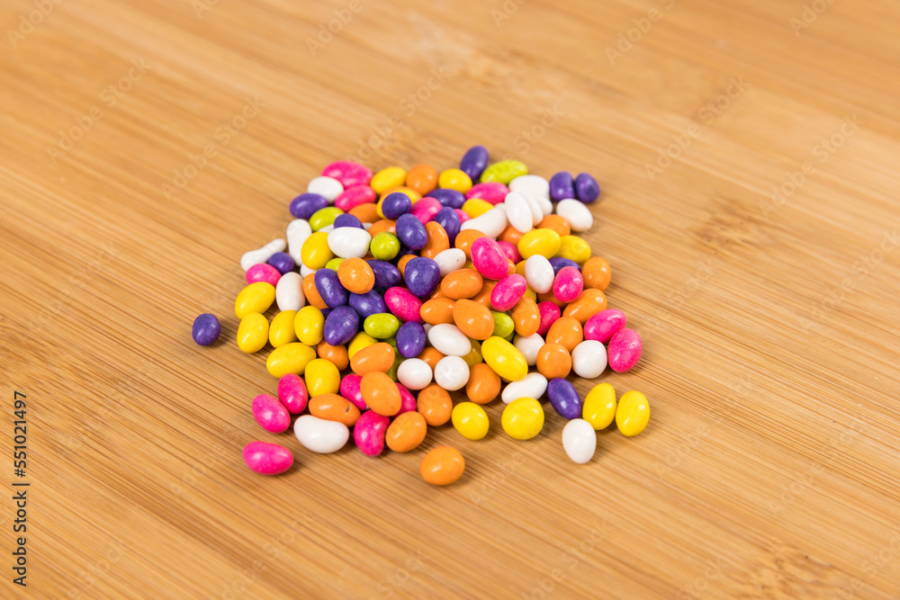 Fennel seed candy in a pile on a wood cutting board side view Fennel seed candy in a pile on a wood cutting board side view