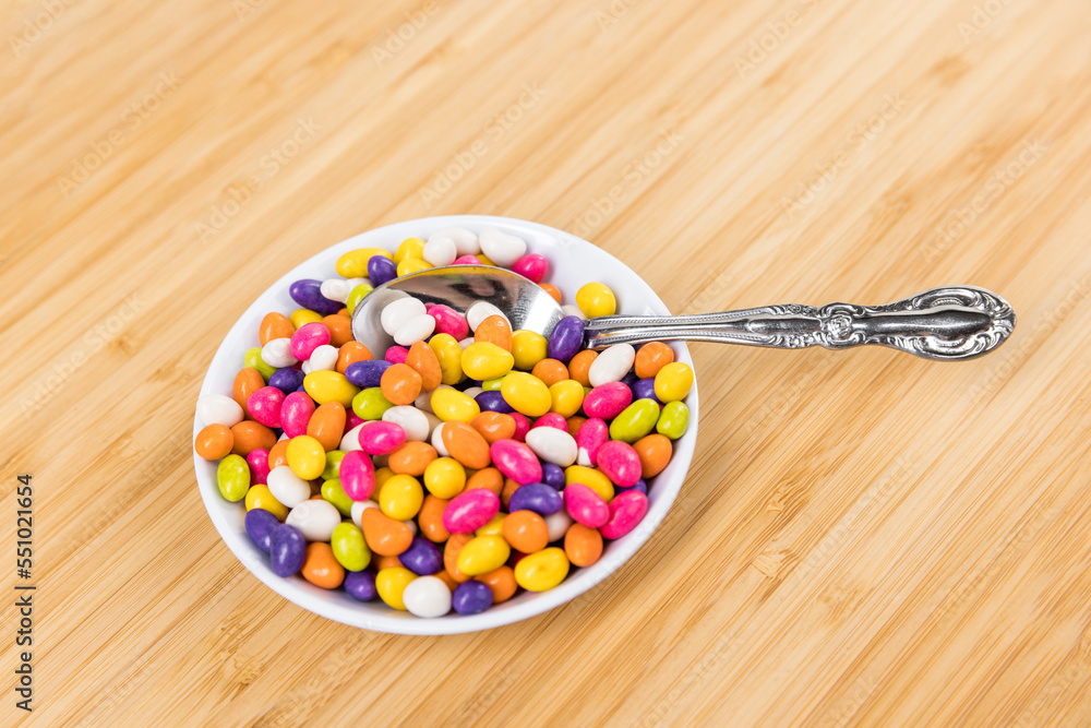 Fennel seed candy in a bowl with a spoon on a wood cutting board Fennel seed candy in a bowl with a spoon on a wood cutting board