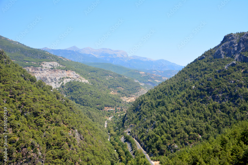 mountains covered with green forest with blue sky on background