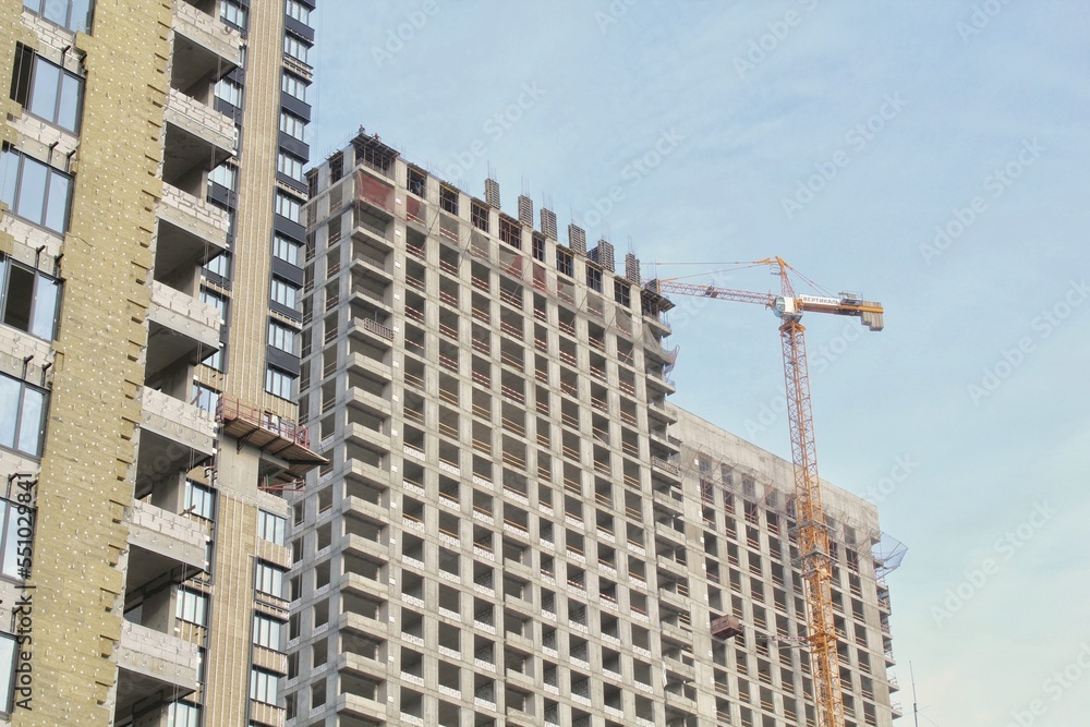 Fototapeta premium Crane and building construction site. Industry modern new civil house business. Concept of development improvement town. Architecture planning of a city. Renovation project. Residential area