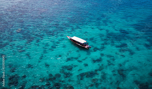 tropical coral reef from above drone shot with boat transparent clear water bali indonesia
