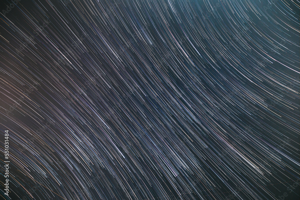 Spin Of Unusual Amazing Stars Effect In Sky. Abstract Bewitching Illusion Of Star Trails. Meteors Trace On Night Dark Blue Sky Background. Soft Colors. Spin Of Unusual Amazing Stars Effect In Sky. Abstract Bewitching Illusion Of Star Trails. Meteors Trace On Night Dark Blue Sky Background. Soft Colors.