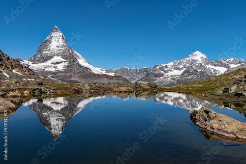 Mountains of the Alps and the Matterhorn reflecting on the water of a lake