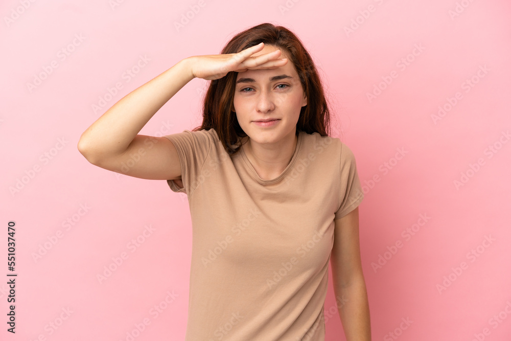 Young caucasian woman isolated on pink background looking far away with hand to look something Young caucasian woman isolated on pink background looking far away with hand to look something
