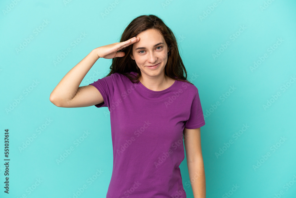 Young caucasian woman isolated on blue background saluting with hand with happy expression Young caucasian woman isolated on blue background saluting with hand with happy expression
