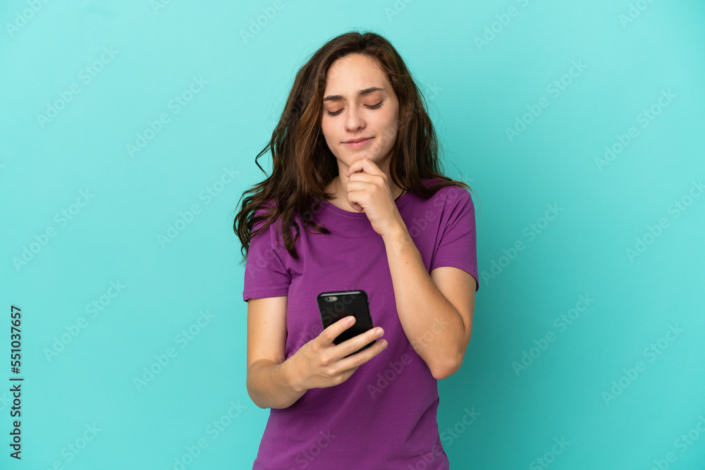 Young caucasian woman isolated on blue background thinking and sending a message Young caucasian woman isolated on blue background thinking and sending a message