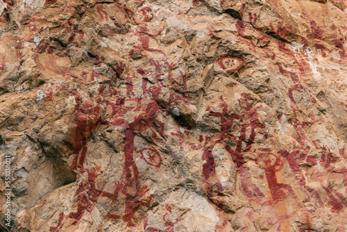 Ancient Rock painting in the region of Guangxi, China. The picture seems to depict hunters on a hunt. © Tatiana Kashko