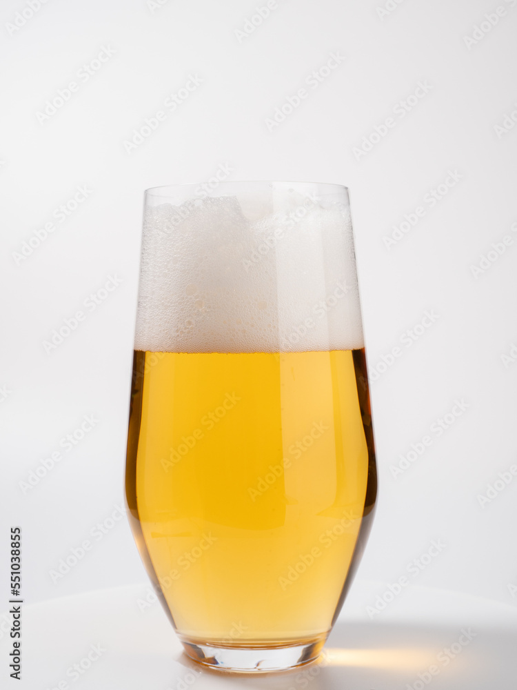 Glass of beer on a white background. A glass of light beer with foam. Glass of beer on a white background. A glass of light beer with foam.