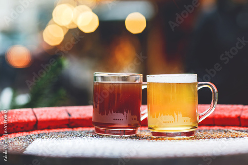 Two glasses mugs with red and white mulled wine on Christmas Market in Germany. Traditional alcoholic drinks on German xmas funfair