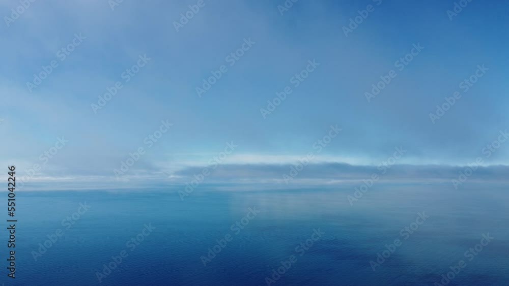 Fog over sea. Abstract aerial nature summer ocean sunset sea and sky background. Small waves on clear water surface with bokeh lights from sunrise. Holiday, vacation and recreational concept Fog over sea. Abstract aerial nature summer ocean sunset sea and sky background. Small waves on clear water surface with bokeh lights from sunrise. Holiday, vacation and recreational concept