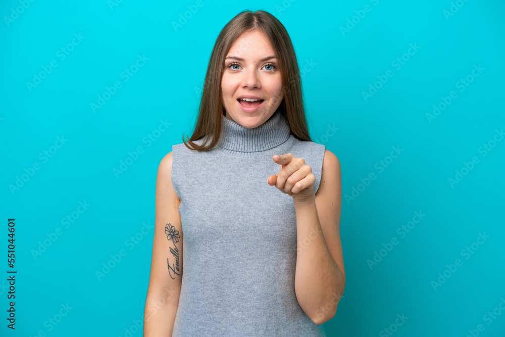 Young Lithuanian woman isolated on blue background surprised and pointing front Young Lithuanian woman isolated on blue background surprised and pointing front