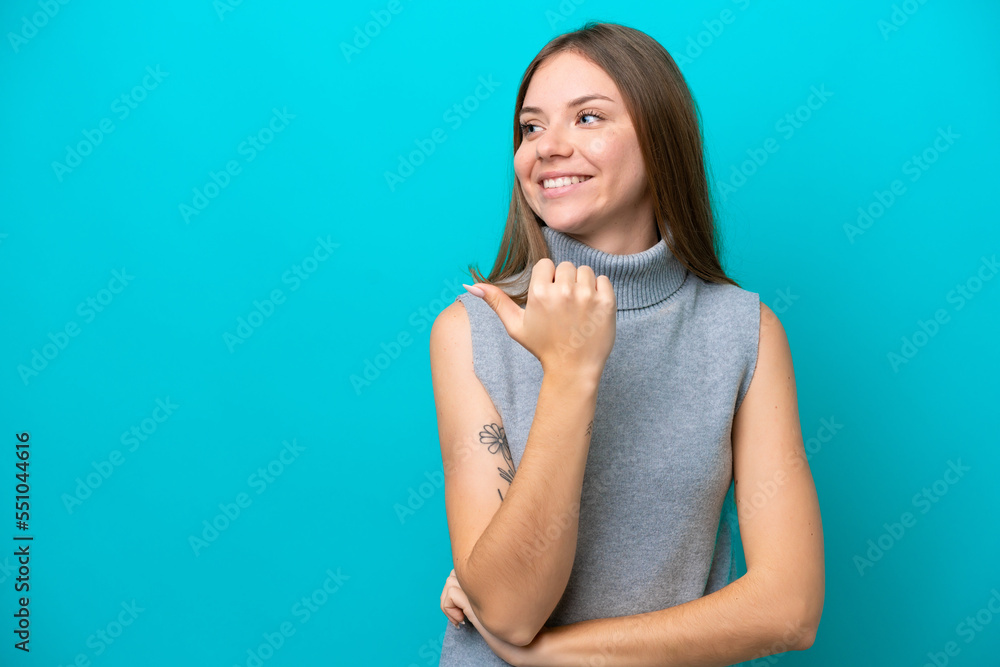 Young Lithuanian woman isolated on blue background pointing to the side to present a product Young Lithuanian woman isolated on blue background pointing to the side to present a product