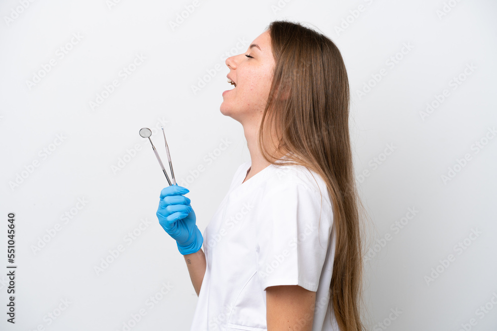 Dentist woman holding tools isolated on white background laughing in lateral position Dentist woman holding tools isolated on white background laughing in lateral position
