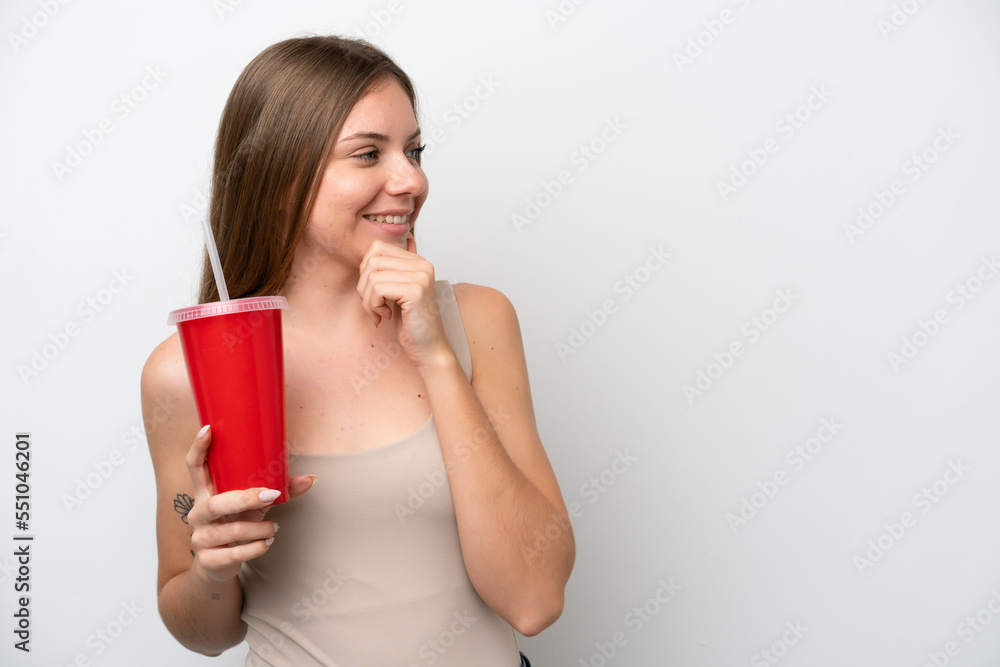 Young Lithuanian woman holding refreshment isolated on white background thinking an idea and looking side Young Lithuanian woman holding refreshment isolated on white background thinking an idea and looking side