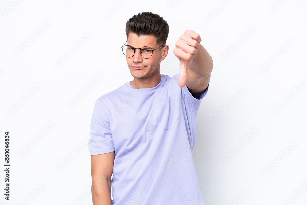 Young caucasian man isolated on white background showing thumb down with negative expression Young caucasian man isolated on white background showing thumb down with negative expression