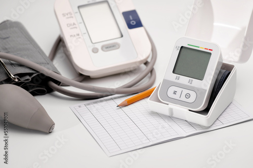 Tonometers, brachial and automatic digital wrist sphygmomanometer lie on the table, pressure diagnostics, on a white background