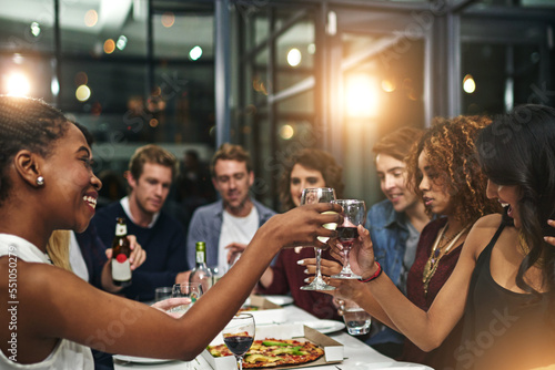 Friends, party and toast with wine for celebration, new year dinner feast and happy with social gathering and friendship. Men, women and food with alcohol drink, pizza and beer to celebrate together.