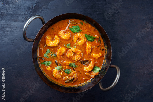 Traditional spicy Indian prawn Madras curry Rogan Josh with king prawns served as top view in a korei bowl with copy space photo