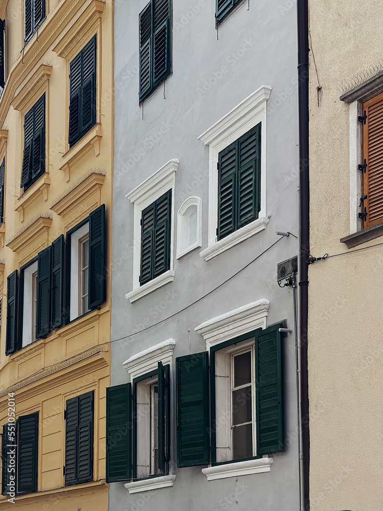 Old ancient historical architecture in Italia. Traditional European buildings with wooden windows, shutters, pastel walls. Summer holidays vacation traveling concept