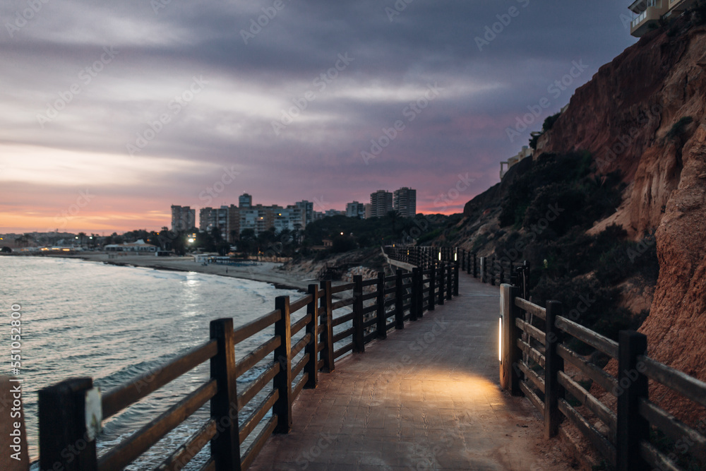 
Beautiful promenade in the late evening along the sea and rocks in Alicante