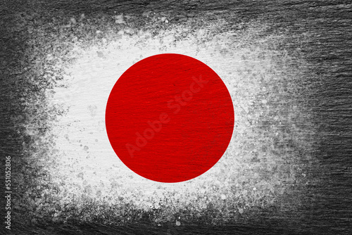 Flag of Japan. Flag is painted on black slate stone. Stone background. Copy space. Textured background