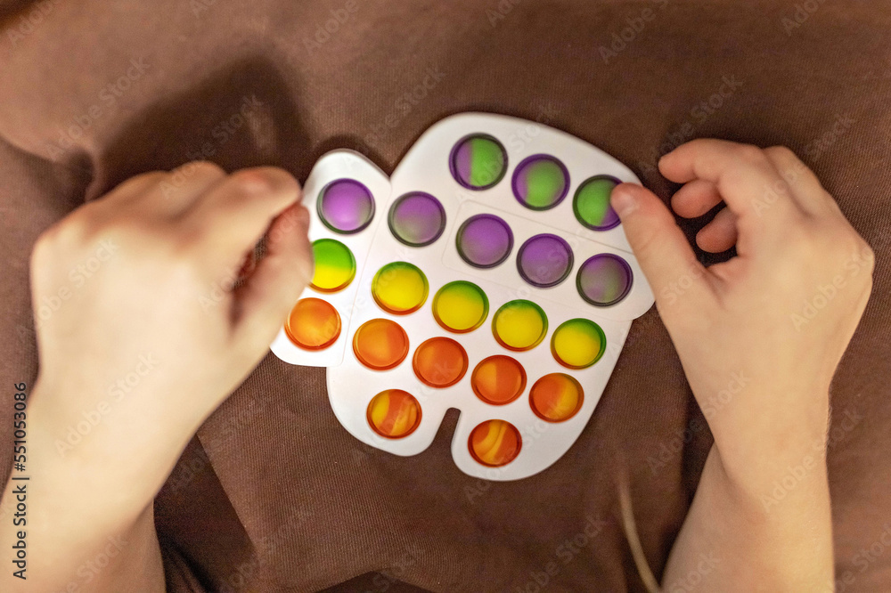 Pop it is a multi-colored anti-stress toy in children's hands. Bubble game. Antistress toys.