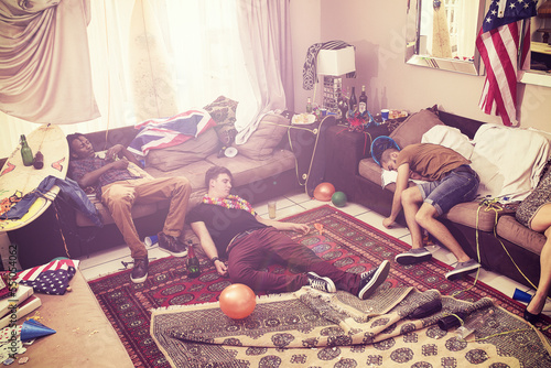Canvas Print Party, drunk and hangover with man friends sleeping on a sofa in the living room of a home after celebration