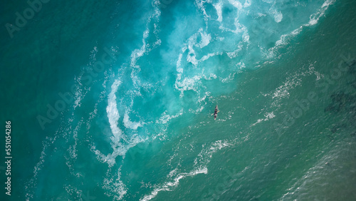 Top view of a man paddles a kayak in raging sea water