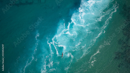 Top view  of a man paddles a kayak in raging sea water © luciano